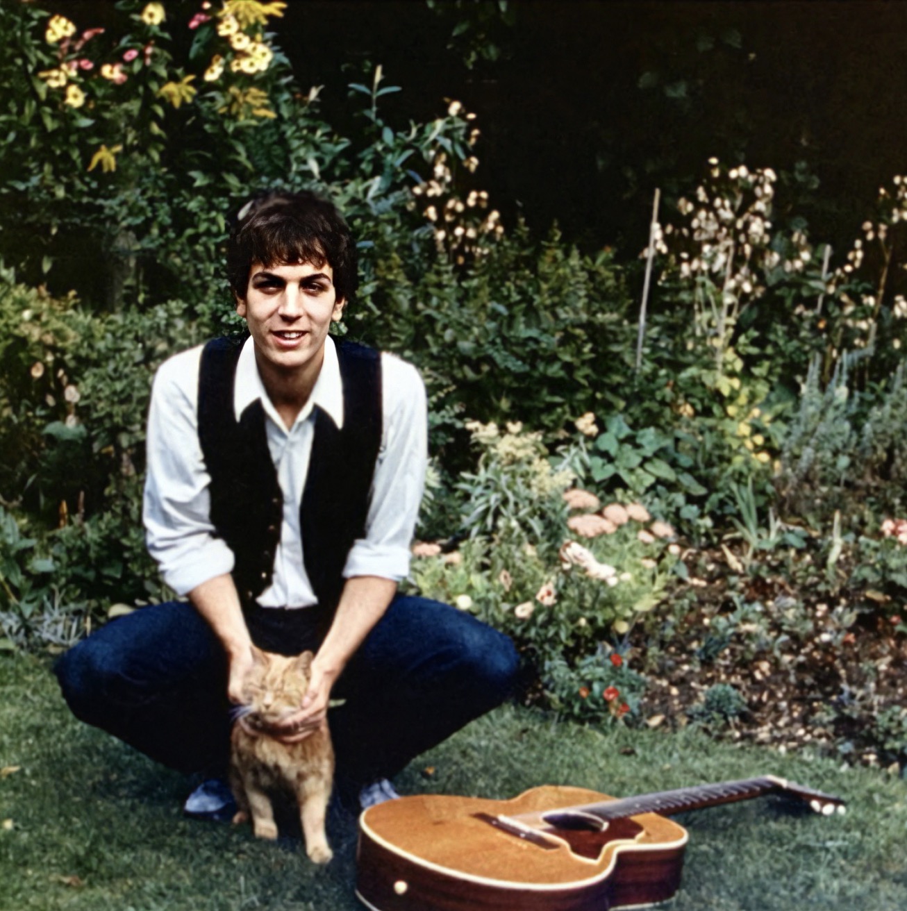 Syd Barrett in the garden with his cat and guitar